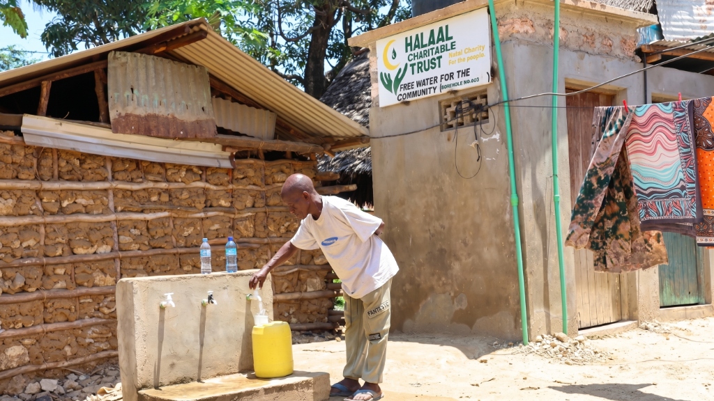 Man collecting clean drinking water from Halaal Charitable Trust borehole